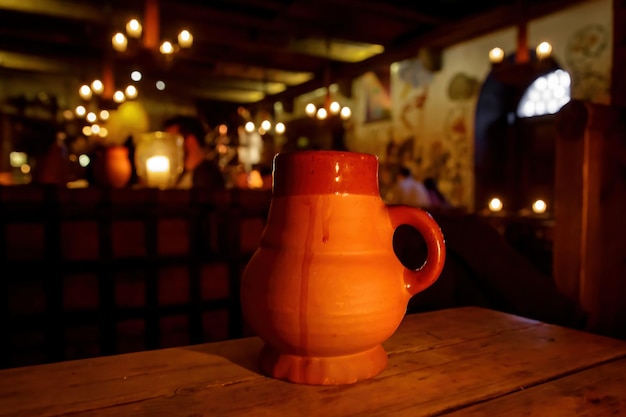 Jarro de barro com cerveja em uma mesa de madeira em uma taverna medieval