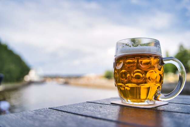 Jarro de cerveja na mesa de madeira