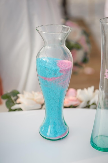 Un jarrón de cristal transparente para celebrar una boda en la arena