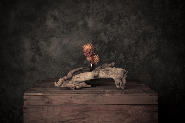 Un jarrón de flores de madera en la mesa contra la pared