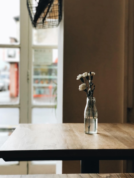 Un jarrón de flores en la mesa de una cafetería