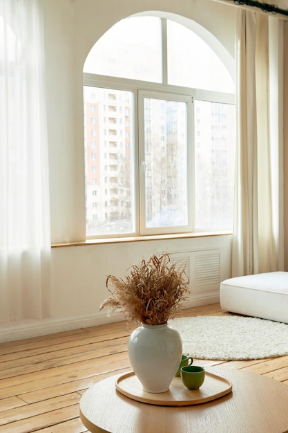 Jarrón con flores en la mesa en la habitación