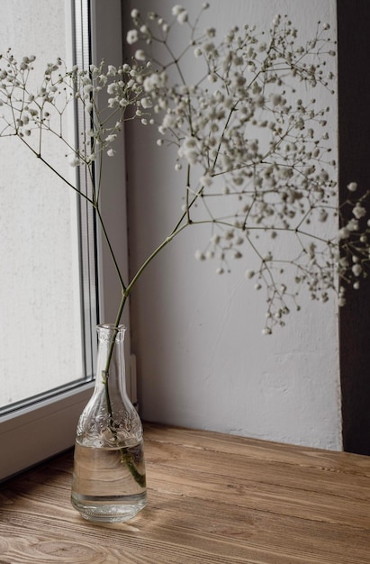 Un jarrón de flores se sienta sobre una mesa de madera.