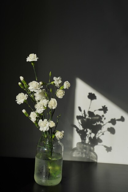 Foto un jarrón de flores con el sol brillando sobre él.