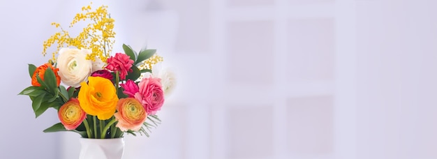 Jarrón con hermosas flores de ranunculus en un espacio de fondo borroso para texto Diseño de banner