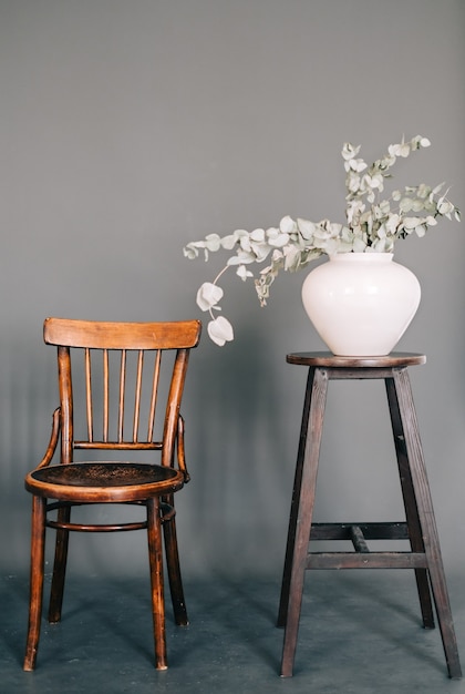 Jarrón con planta verde en silla vintage de madera