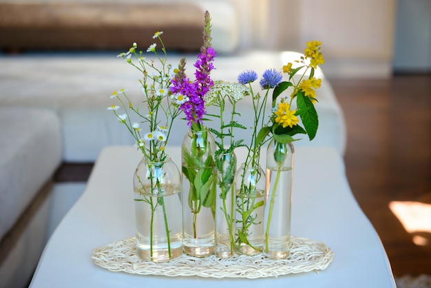 Jarrones de vidrio con las flores en una mesa