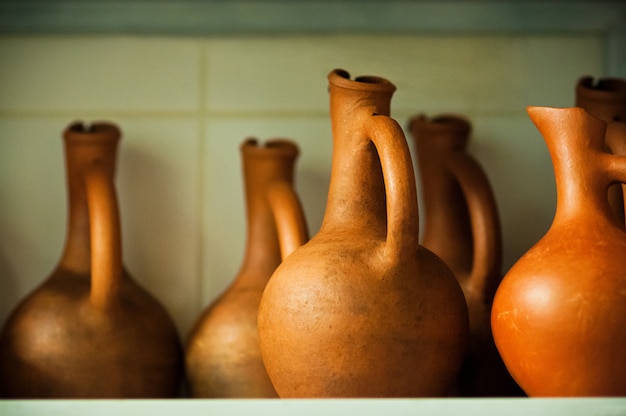 Jarros de vinho de cor terracota com foco suave na prateleira