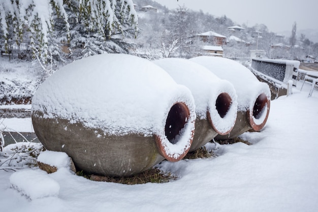 Jarros georgianos cobertos de neve para vinho, ao ar livre no inverno