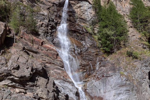 Jatos espumantes da cachoeira alpina de montanha Lillaz descem corredeiras de granito