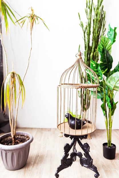 Una jaula con un pájaro artificial en su interior como elemento de decoración en el interiorismo. Foto vertical