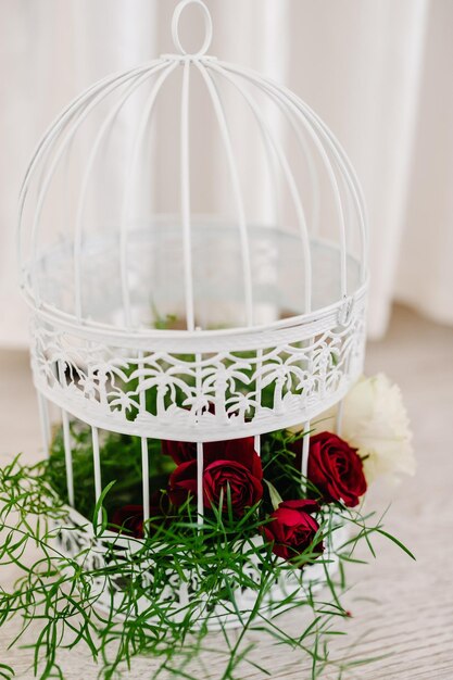 Jaula de pájaros con flor primaveral de rosas flores Decoraciones de boda con espacio de copia Cabezas de flores nupciales en una jaula de pájaros ornamentada en una recepción de boda