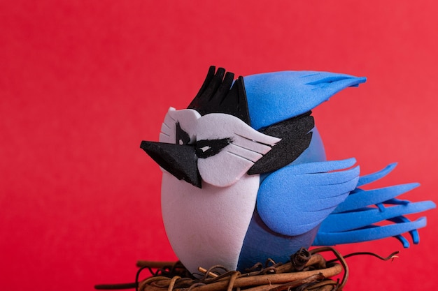 Jay azul en un nido con un fondo rojo decorado con huevos de Pascua