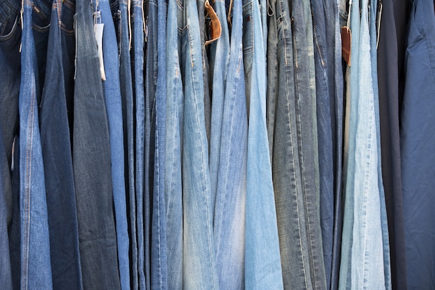 Los jeans cuelgan en fila. Pantalones de tela tejida