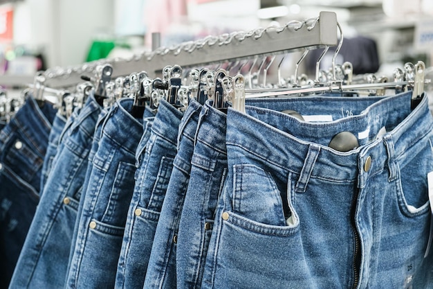 Jeans em cabides na prateleira de uma loja de roupas de varejo