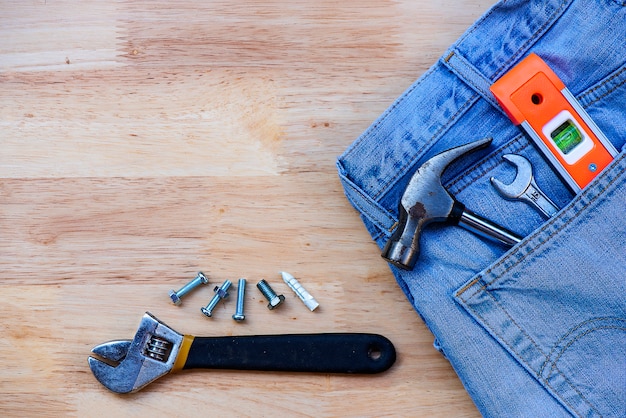 Jeans y equipo de construcción en el piso de madera.