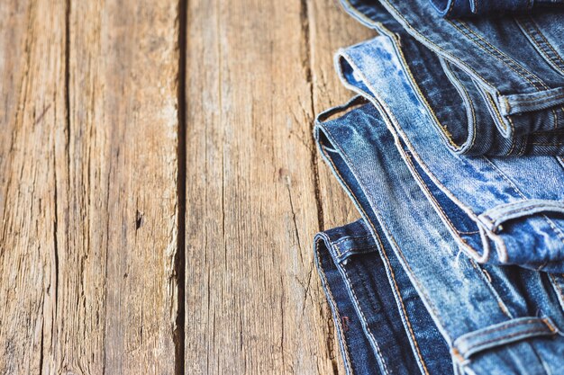 Jeans gestapelt auf einem hölzernen Hintergrund