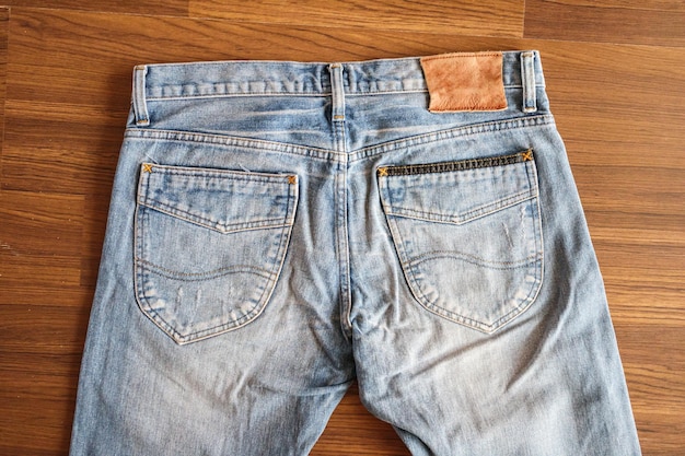 Jeans jeans com etiqueta de couro em branco sobre fundo de madeira