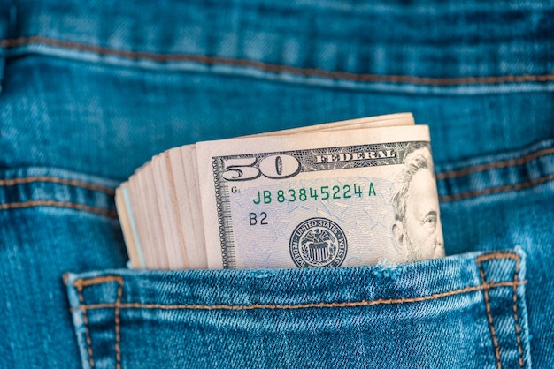 Jeans mit US-Dollar-Scheinen in einer Tasche. Dollar in Jeans. Finanzielles Konzept.