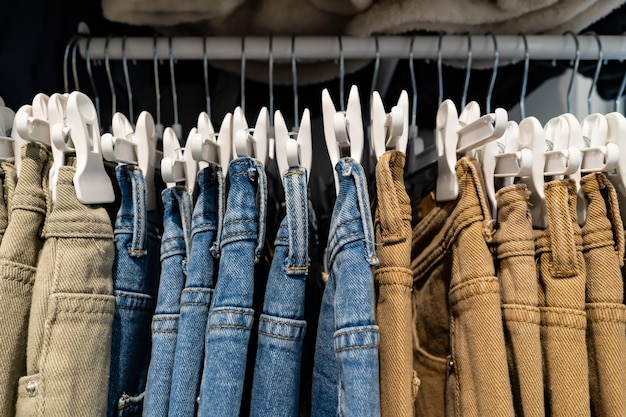 Los jeans de moda cuelgan de una percha en la tienda