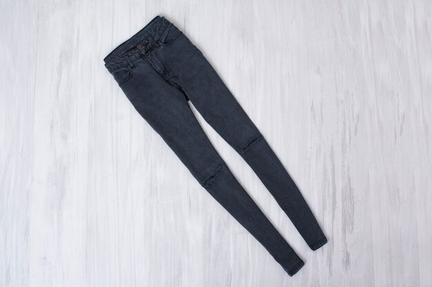 Jeans rasgado cinza em madeira