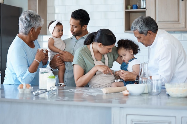 Jeder will in der Küche mithelfen. Aufnahme einer Familie mit mehreren Generationen, die gemeinsam in der Küche backt.