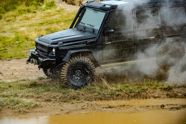 Jeep todoterreno expedición a los pueblos en la carretera de montaña clásico x coche cruzando el agua con salpicaduras ...