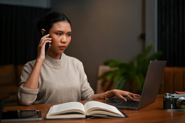 Una jefa asiática inteligente que tiene una conversación seria por teléfono con su socio comercial