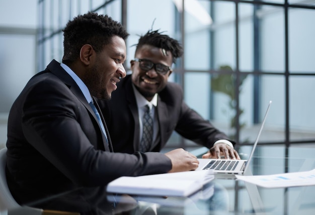 Jefe afroamericano negociando los detalles del contrato con el cliente corporativo de la empresa