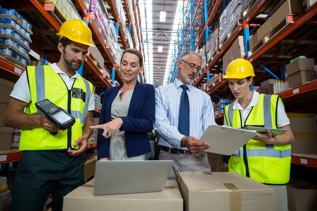 Jefe de almacén y cliente interactuando con compañeros de trabajo