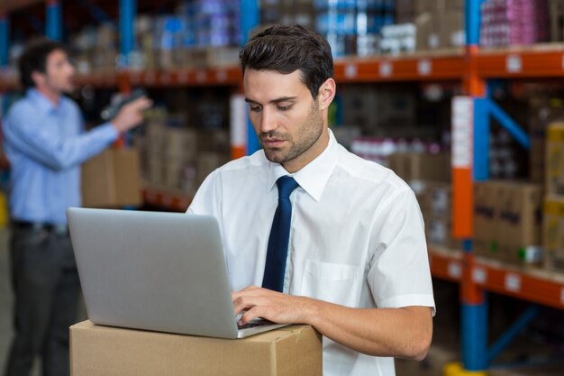 Jefe de almacén trabajando en laptop