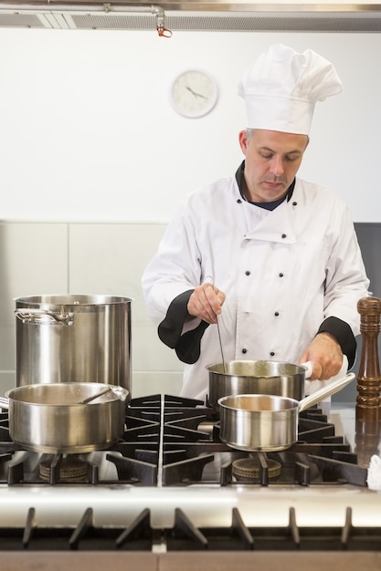 Jefe de cocina concentrado mirando dentro de la olla