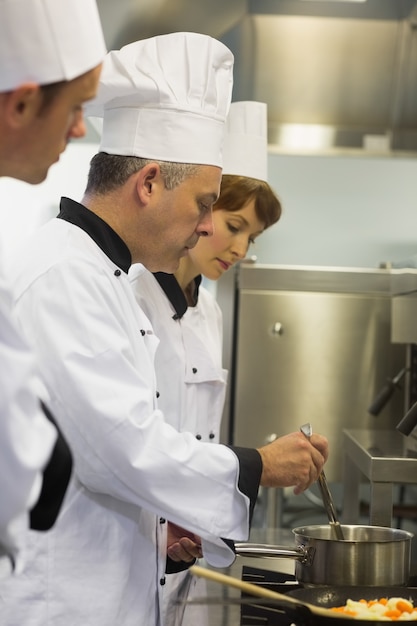 Jefe de cocina inspeccionando su olla de estudiantes