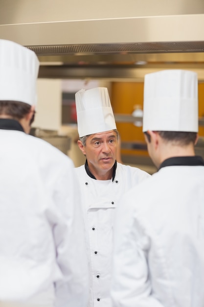 Foto jefe de cocina regañando empleados