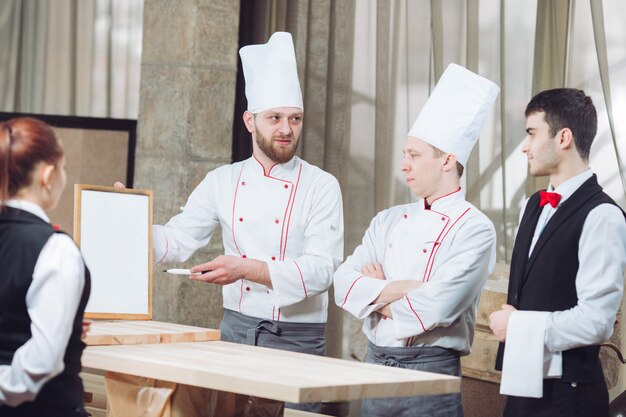 Jefe de cocina y su personal en la cocina. interactuando en cocina comercial.