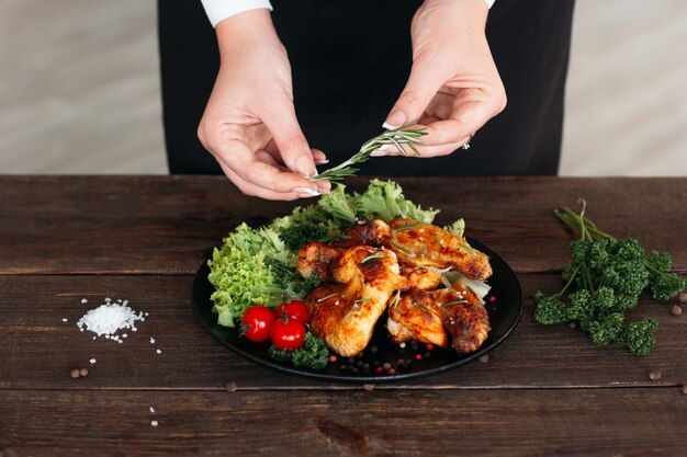 Jefe decorando plato de alitas de pollo picante