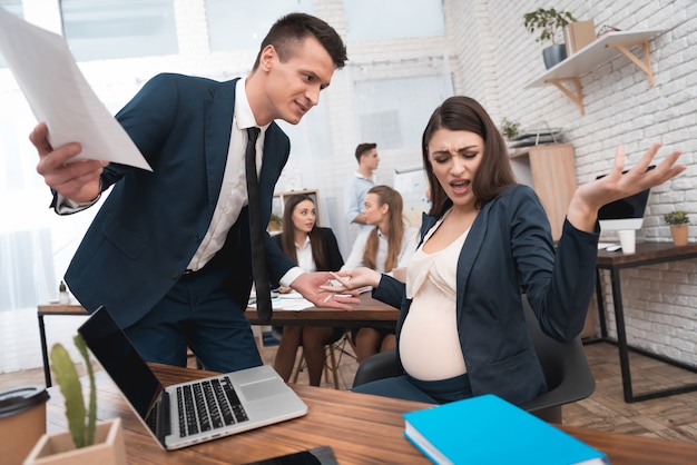Jefe enojado enojado gritándole a una empleada embarazada