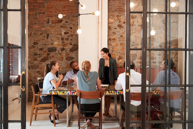 Jefe femenino dirigiéndose al equipo de negocios en una sala de reuniones