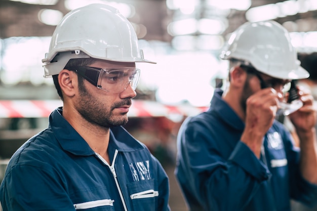 Jefe de ingeniero, trabajador líder retrato confianza en sí mismo y aspecto profesional con gafas de seguridad y casco blanco.