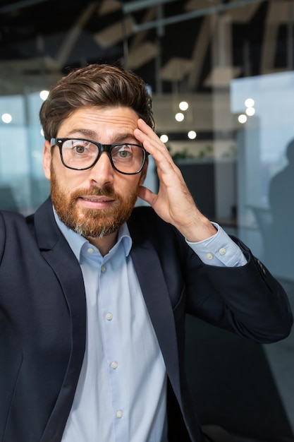 Jefe de negocios de videollamada de disparo vertical hablando de forma remota usando la aplicación de teléfono inteligente y mirando