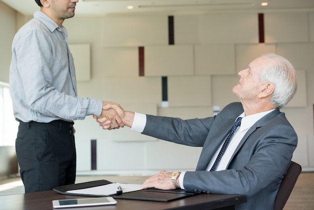 Jefe respetable que toma apretón de manos con el empleado