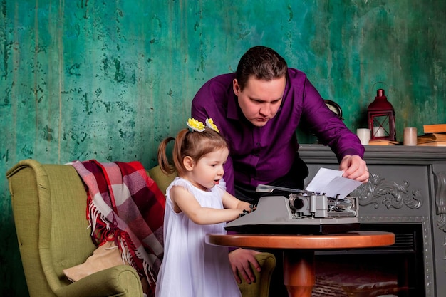 El jefe revisa el documento de una niña de tres años en la sala de la oficina escribiendo en una vieja máquina de escribir