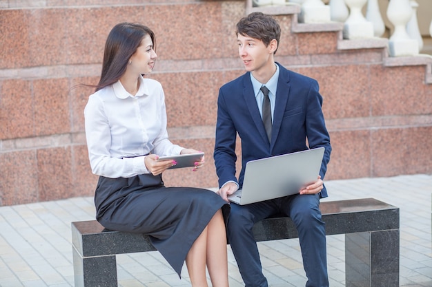 Jefe y su asistente discutiendo su trabajo al aire libre