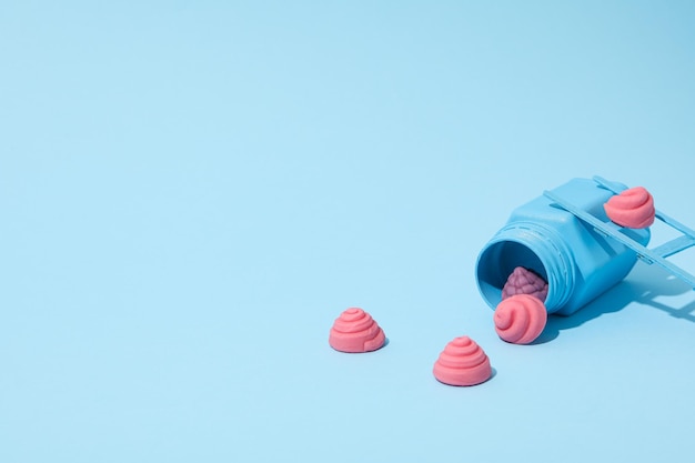 Jelly-Süßigkeiten und blaues Glas auf hellblauem Hintergrund für den Text