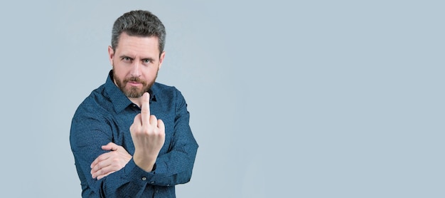 Jemanden ausschalten Bärtiger Mann zeigt Mittelfinger nach oben Obszöne Handgeste fick dich Mann Gesicht Portrait Banner mit Kopierraum