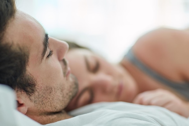 Jemanden zu haben, mit dem man sein Leben teilen kann, ist wunderschön Aufnahme eines entspannten jungen Paares, das zu Hause im Bett schläft