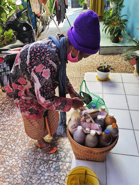 Jepara Indonesia en julio de 2022 Una abuela que vende hierbas medicinales está preparando un pedido de 39s del cliente