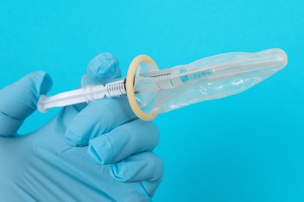 Foto jeringa contra el concepto de vacunación en un condón