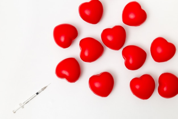 Jeringa con corazón rojo. Aislado en el fondo blanco. Iluminación de estudio. Concepto para saludable y medi