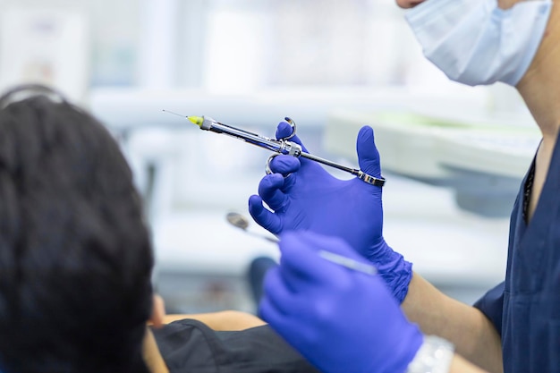 Foto jeringa dental en mano de dentista. médico haciendo anestesia al paciente.